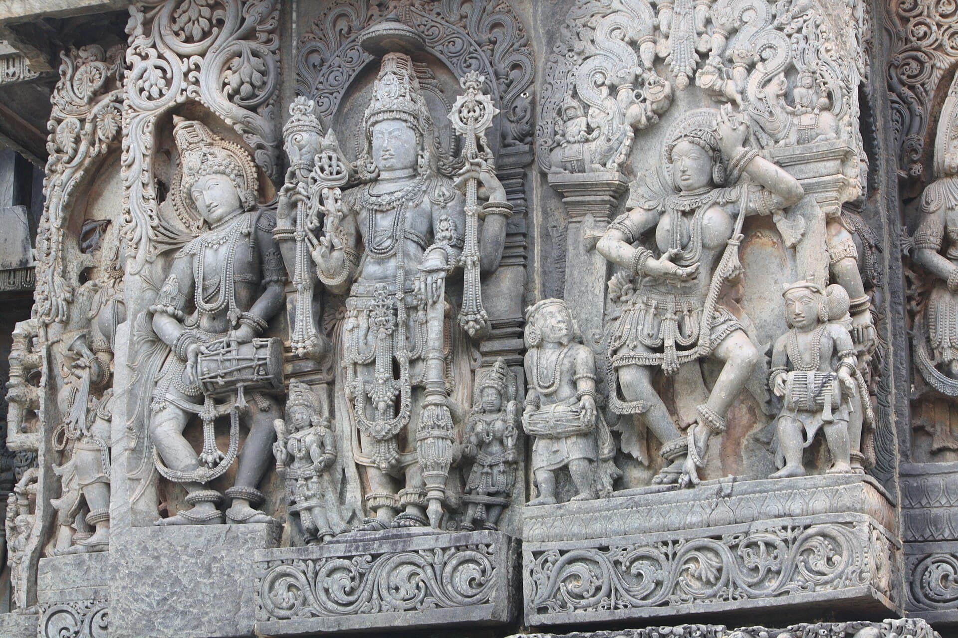 Carved deities wearing intricate jewellery on the walls of Hoysaleswara Temple, Halebidu